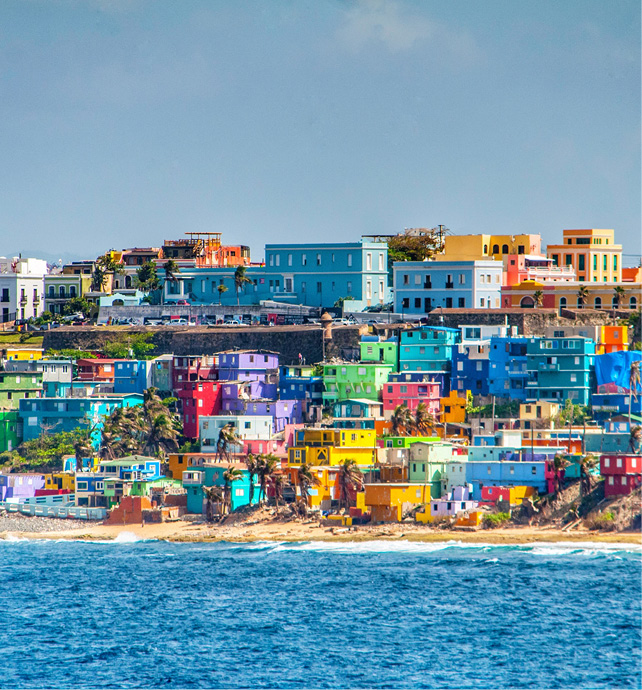 Bright, colourful houses overlooking the beach and blue seas on a sunny day in San Juan, Puerto Rico